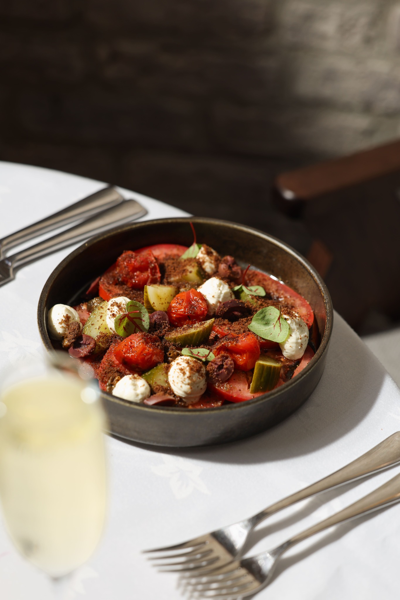 Greek salad with tomatoes, cucumber, olives and feta on a Yammas table