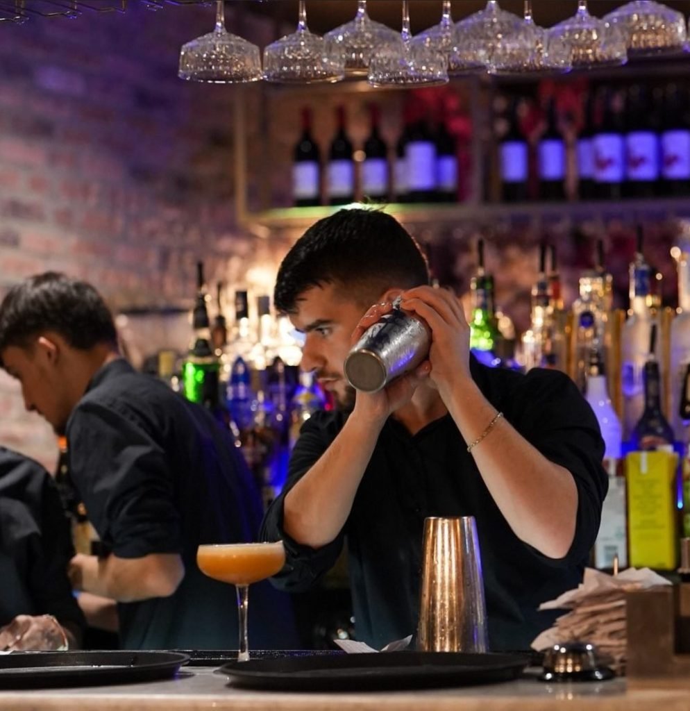 Bartender preparing a cocktail at Yammas restaurant in Beckenham, serving handcrafted drinks at the bar