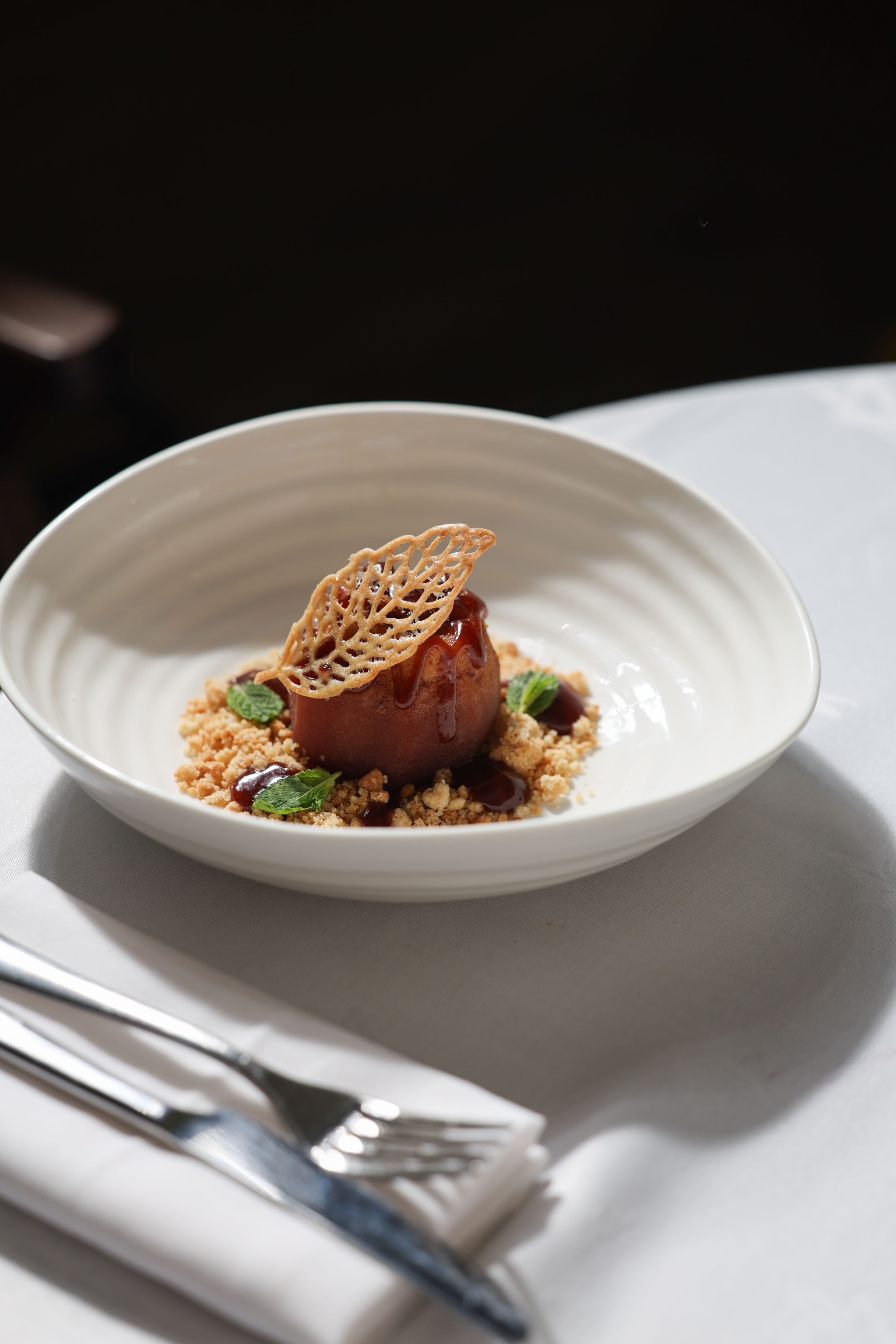 Roasted apple dessert with a delicate crisp in a white bowl